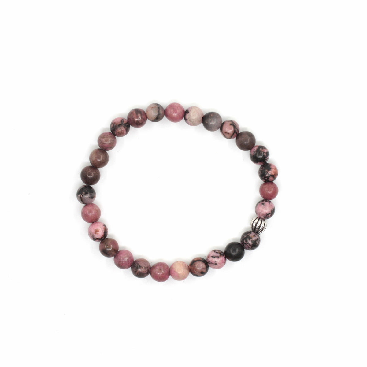 Rodoniitti rannekoru valkoisella alustalla. Rhodonite bracelet on a white surface.