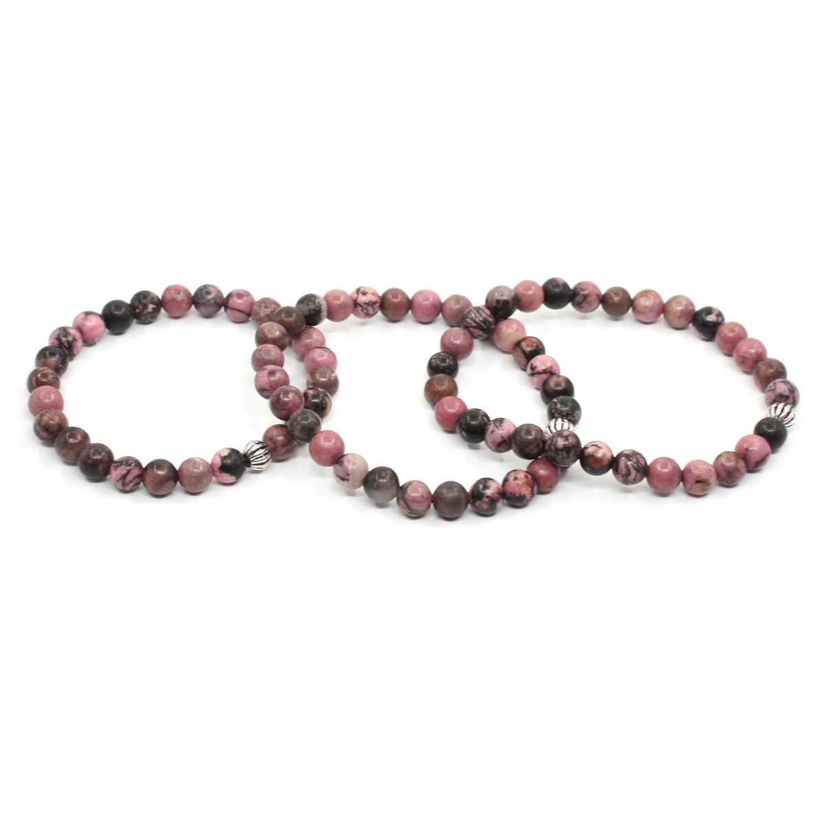 Kolme rodoniitti rannekorua ranteessa. Tausta on valkoinen. Three rhodonite bracelets on the wrist. Background is white.