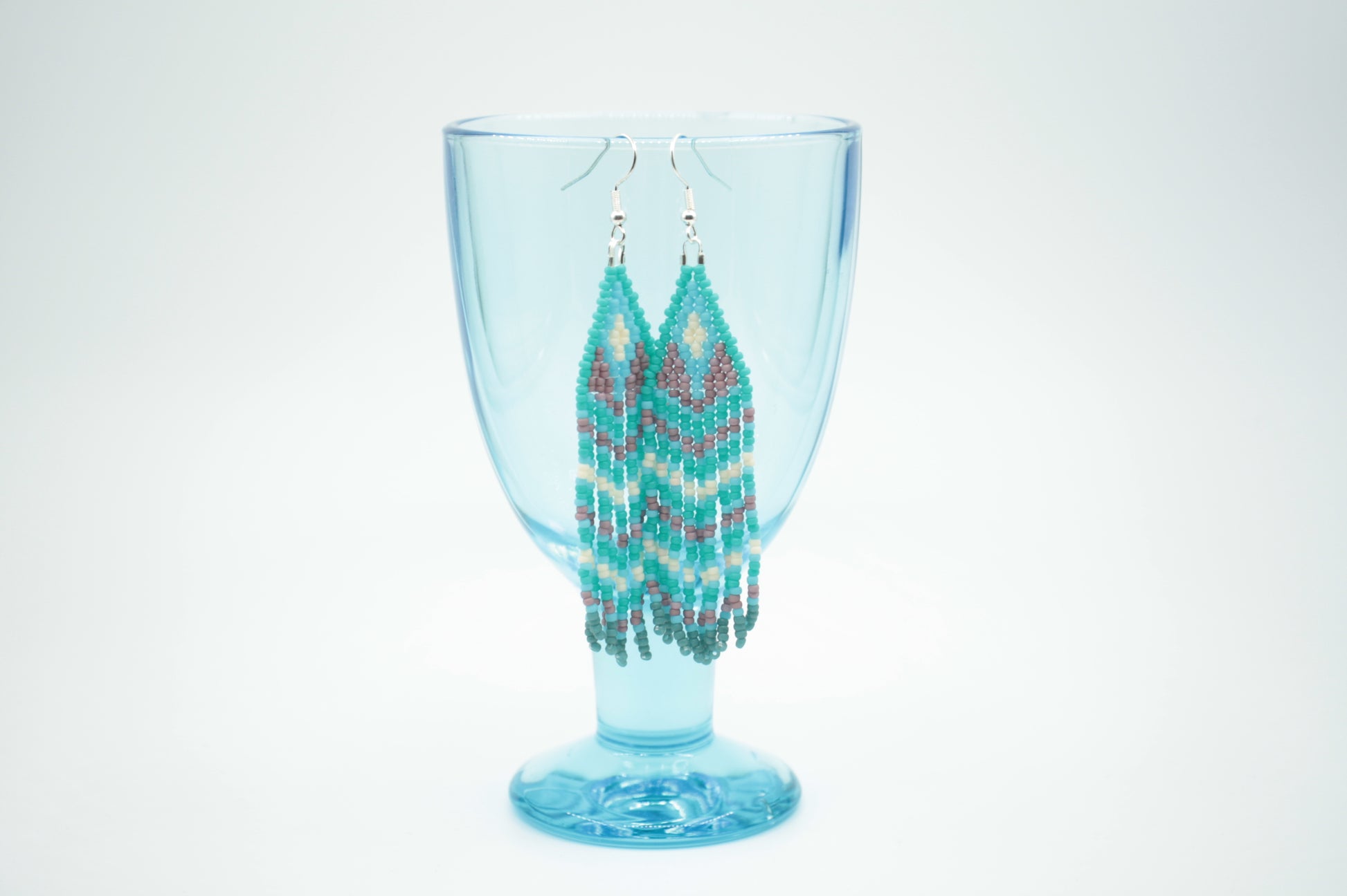 Roikkuvat hapsulliset lasihelmikorvakorut. Väreinä vihreäturkoosi, turkoosi, valkoinen ja kanerva. Seed bead fringe earrings with green turquoise, turquoise, white and purple color.