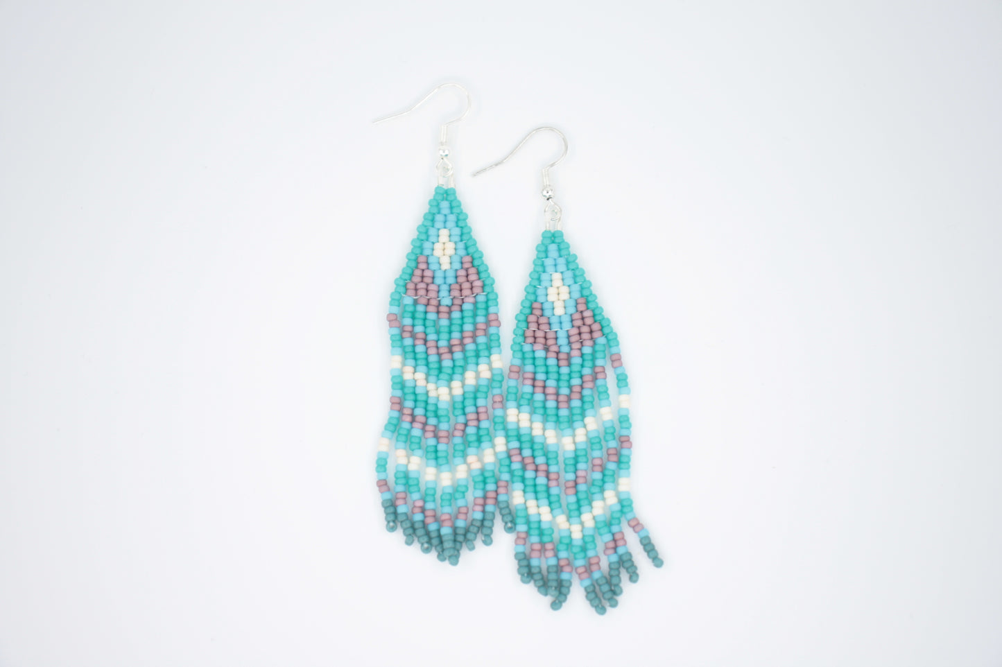 Roikkuvat hapsulliset lasihelmikorvakorut. Väreinä vihreäturkoosi, turkoosi, valkoinen ja kanerva. Seed bead fringe earrings with green turquoise, turquoise, white and purple color.