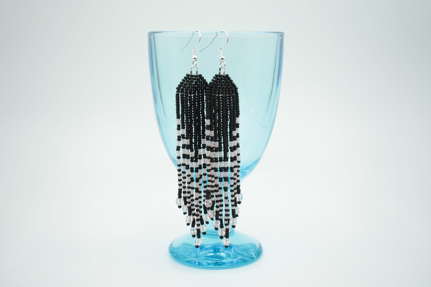 Pitkä roikkuvat hapsulliset helmikorvakorut matta musta vaalean pinkeillä raidoilla. Long seed bead fringe earrings with matte black beads and light pink stripes.