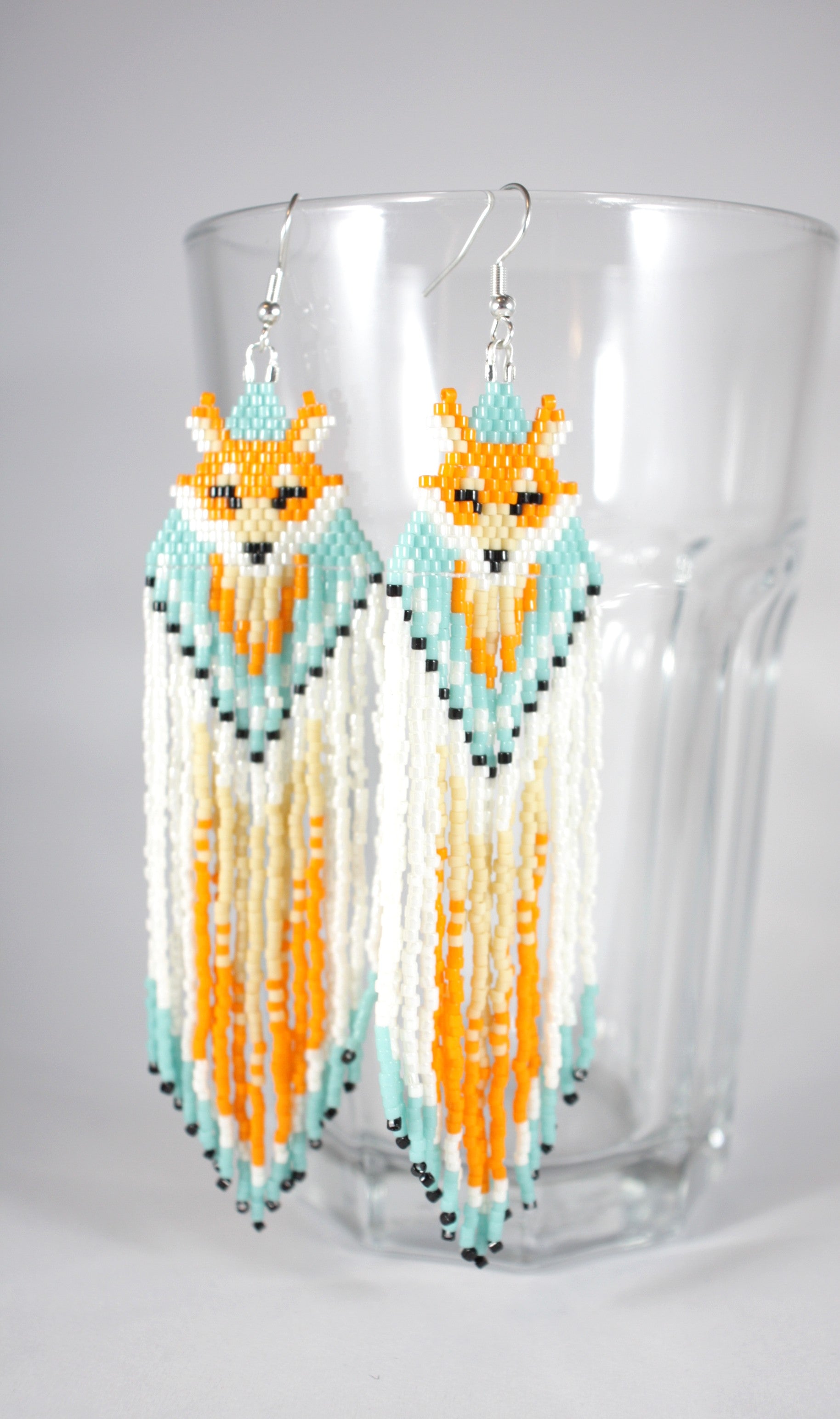 Hapsulliset lasihelmikorvakorut ketut värinä oranssi-siniturkoosi. Seed bead fringe earrings foxes, color orange and blueturquoise.