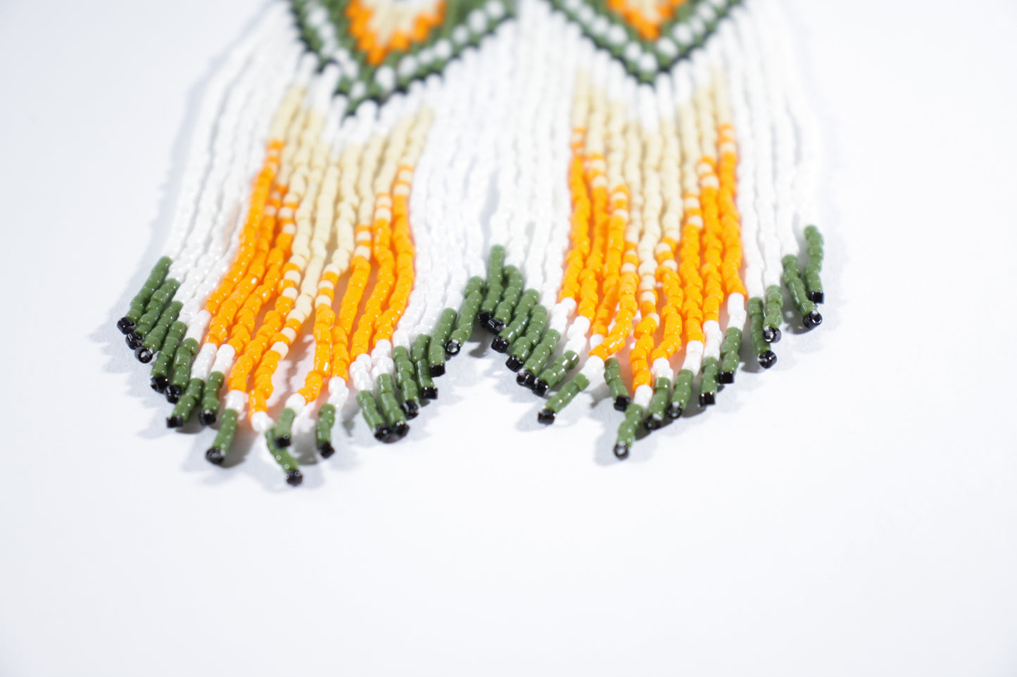 Long handmade seed bead fringe earrings foxes  with green and orange color. Pitkät roikkuvat hapsulliset käsintehdyt kettu helmikorvakorut väreinä oranssi-vihreä.