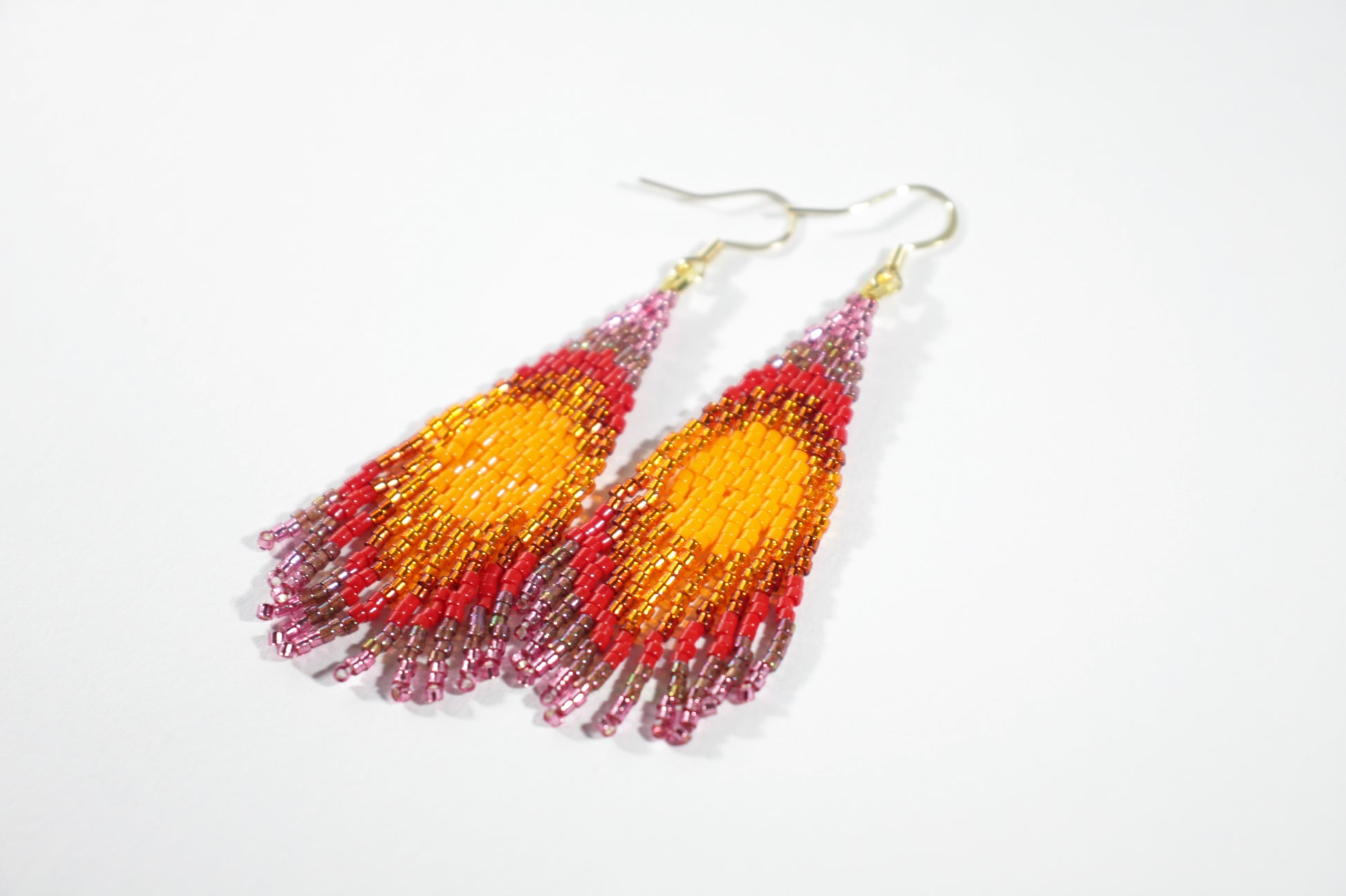 Colorful handmade seed bead fringe earrings. Colors are orange, red, violet and raspberry. Värikkäät käsintehdyt roikkuvat hapsukorvakorut. Väreinä oranssia, punaista, lilaa ja vadelmaa. 