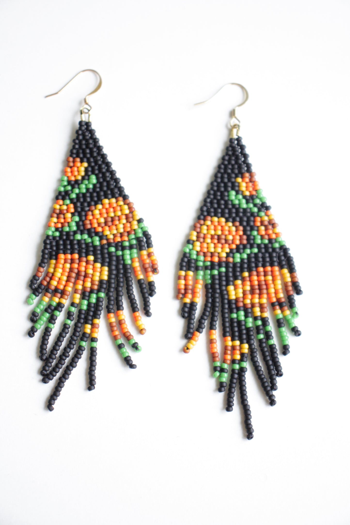 Seed bead fringe earrings matte black wit orange brown roses pattern. Pitkät roikkuvat hapsuhelmikorvakorut. Pohjaväri on mattamusta, jossa oranssin ja ruskean sävyisiä ruusukuvioita.