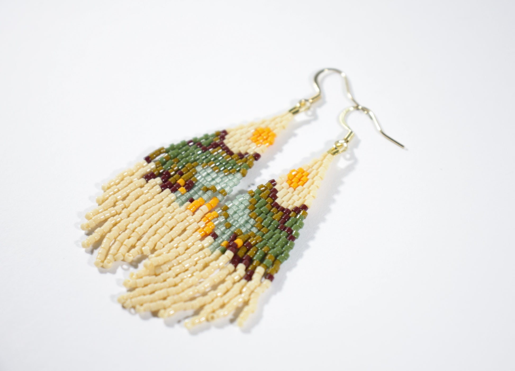 Seed bead delica fringe earrings with  landscape pattern. Colorful with beige base color. Käsintehdyt roikkuvat hapsukorvakorut maisema kuviolla. Pohjaväri on beige.