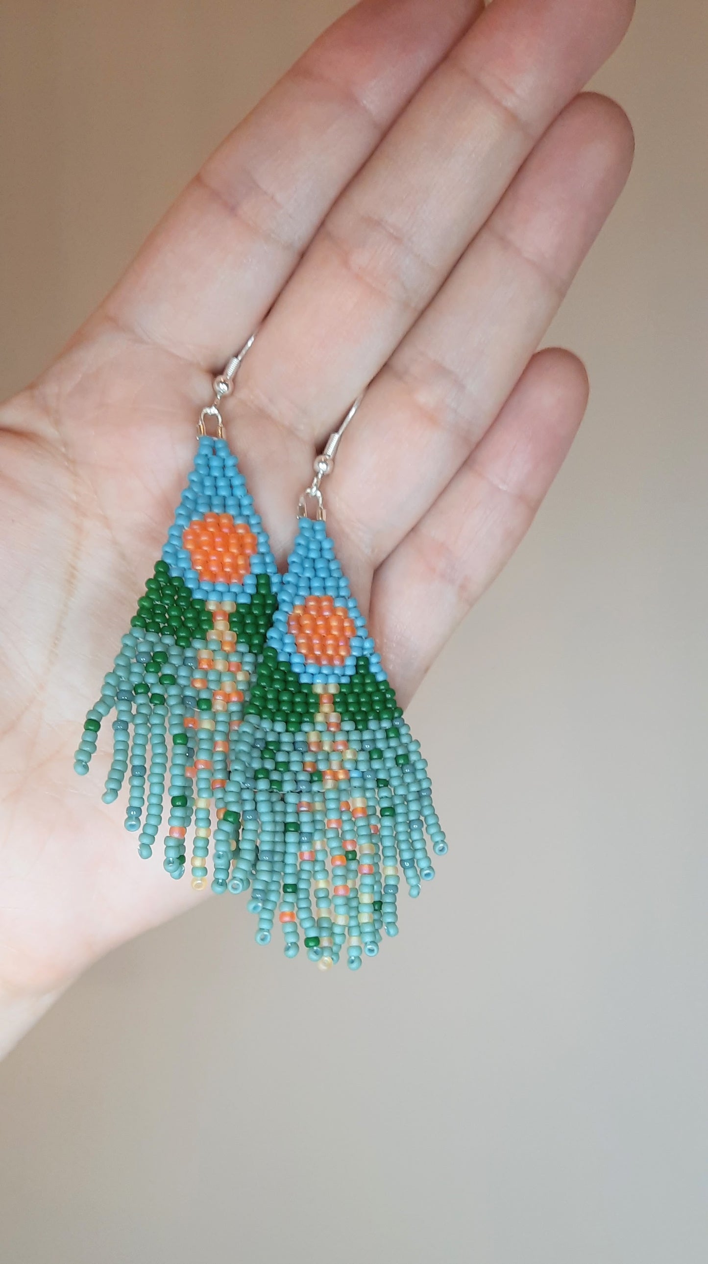 Seed bead fringe earrings with landscape pattern. Colors are turquoise, blue and orange. Roikkuvat boho helmikorvakorut maisema kuviolla. Väreinä ovat turkoosi, sininen, vihreä ja oranssi.