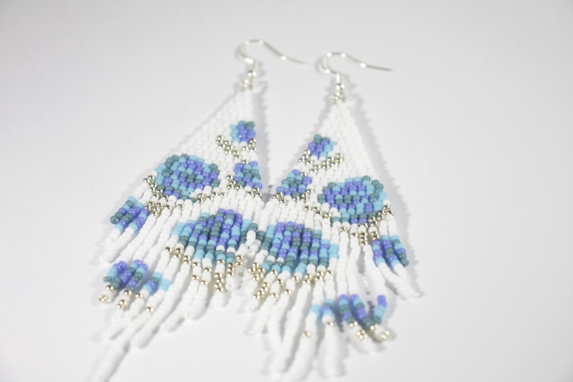 Long fringe seed bead earrings white with shades of blue roses pattern. Pitkät roikkuvat helmikorvakorut. Värinä valkoinen, jossa sinisen sävyisiä ruusuja kuvioina. 