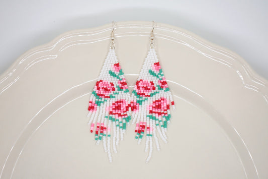 Long beaded seed bead fringe earrings. Base color of these earrings is white and has red and pink roses pattern. Pitkät käsintehdyt roikkuvat helmikorvakorut. Pohjaväri näissä korvakoruissa on valkoinen sekä, kuviona on punaisia ja pinkkejä ruusuja.  