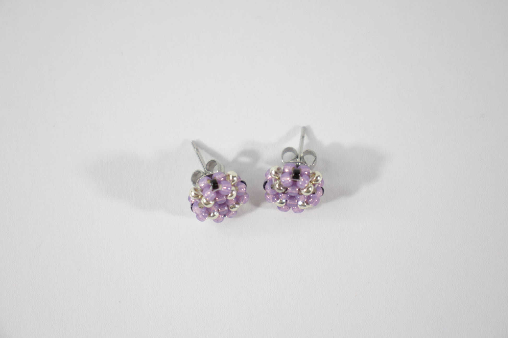 Seed bead stud earrings lila and silver color. Pienistä lasihelmistä tehdyt nappikorvakorut väriltään lila ja hopea. 