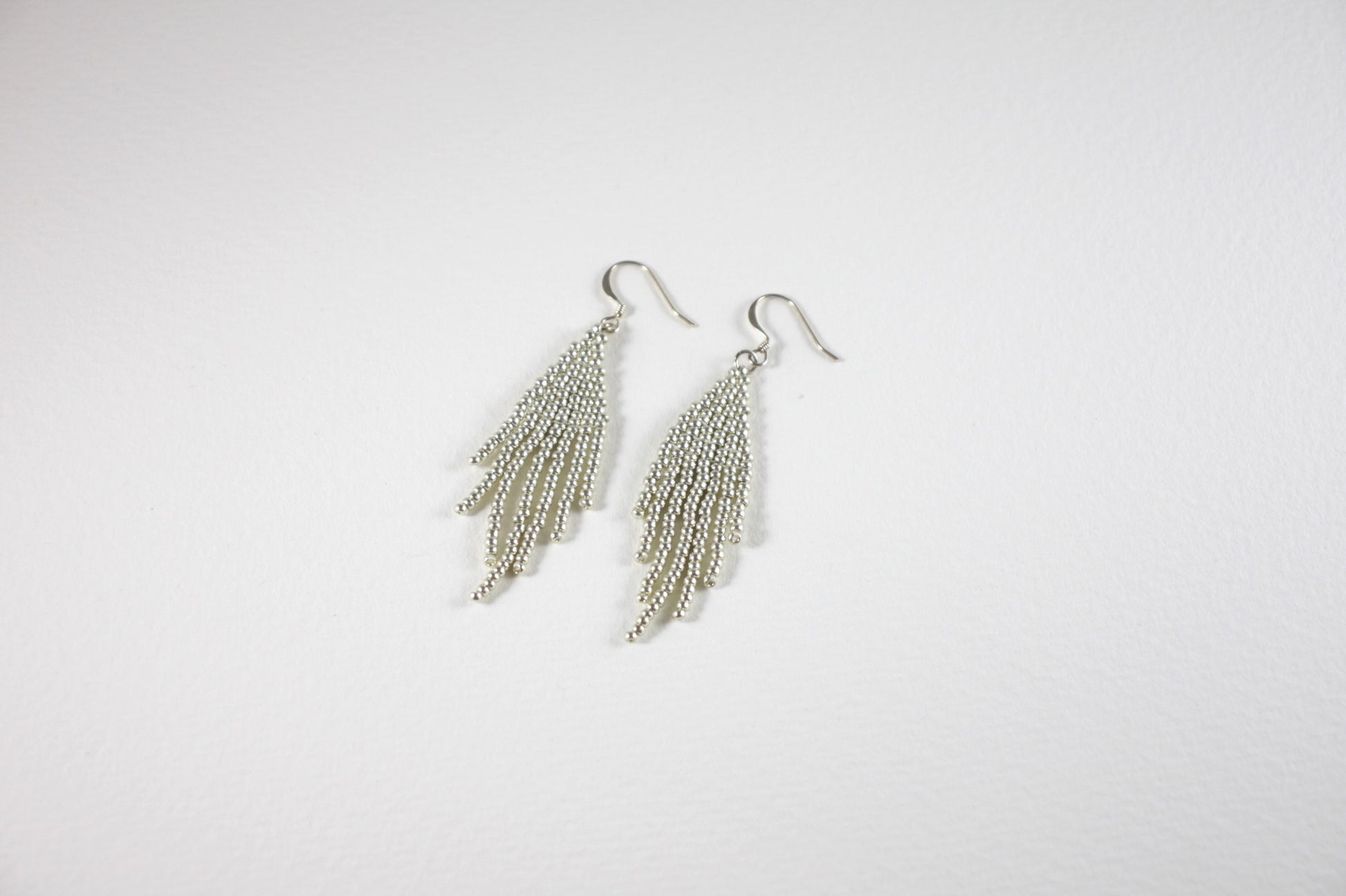 Silver color seed bead fringe earrings small. Lasihelmistä tehdyt hopeanväriset hapsukorvakorut, pienet.