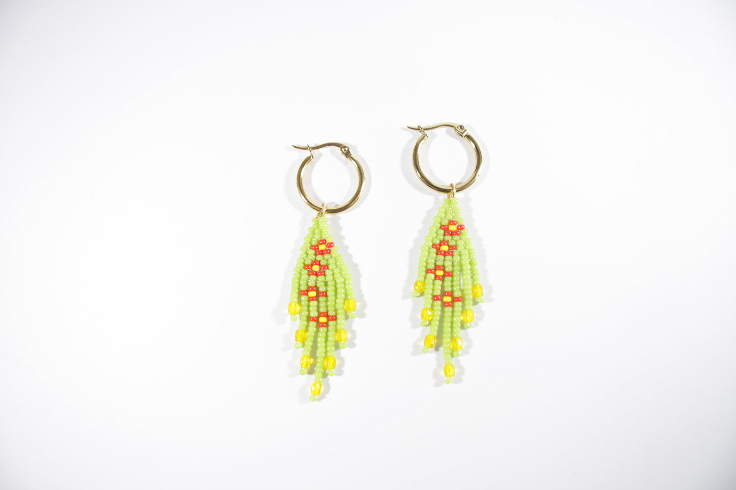 Small fringe seed bead earrings daisies. Color is green and daisies flowers are red with yellow center. Earrings hoops are gold plated stainless steel. Pienet hapsulliset lasihelmikorvakorut kukka kuviolla. Väri on vihreä ja kukat oat punaisia ja niiden keskusta on keltainen. Korvakorurenkaat ovat kullattua ruostumatonta terästä.