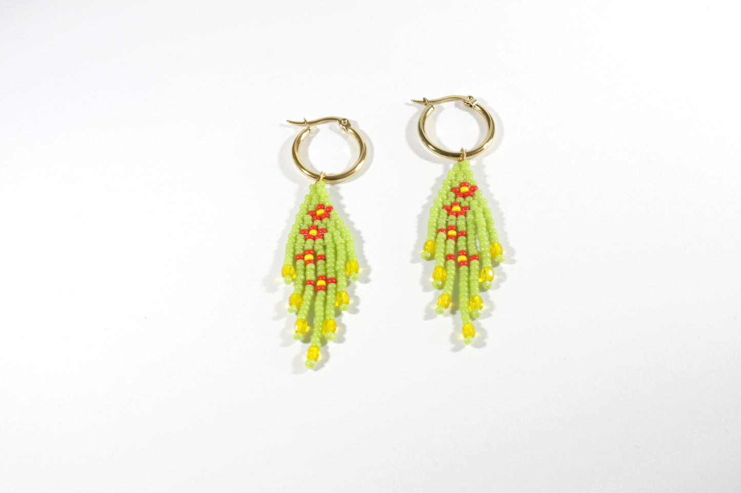 Small fringe seed bead earrings daisies. Color is green and daisies flowers are red with yellow center. Earrings hoops are gold plated stainless steel. Pienet hapsulliset lasihelmikorvakorut kukka kuviolla. Väri on vihreä ja kukat oat punaisia ja niiden keskusta on keltainen. Korvakorurenkaat ovat kullattua ruostumatonta terästä.