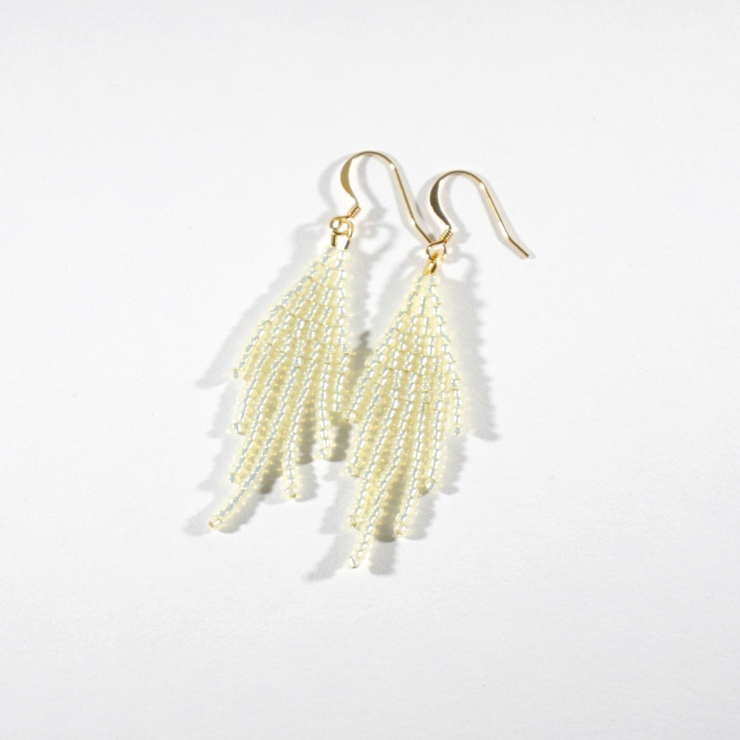 Seed bead fringe earrings sparkling cream small with gold color hooks. Lasihelmistä tehdyt pienet hapsukorvakorut väriltään kimalteleva kerma. Koulut ovat kullattua nikkelitöntä korumetallia.