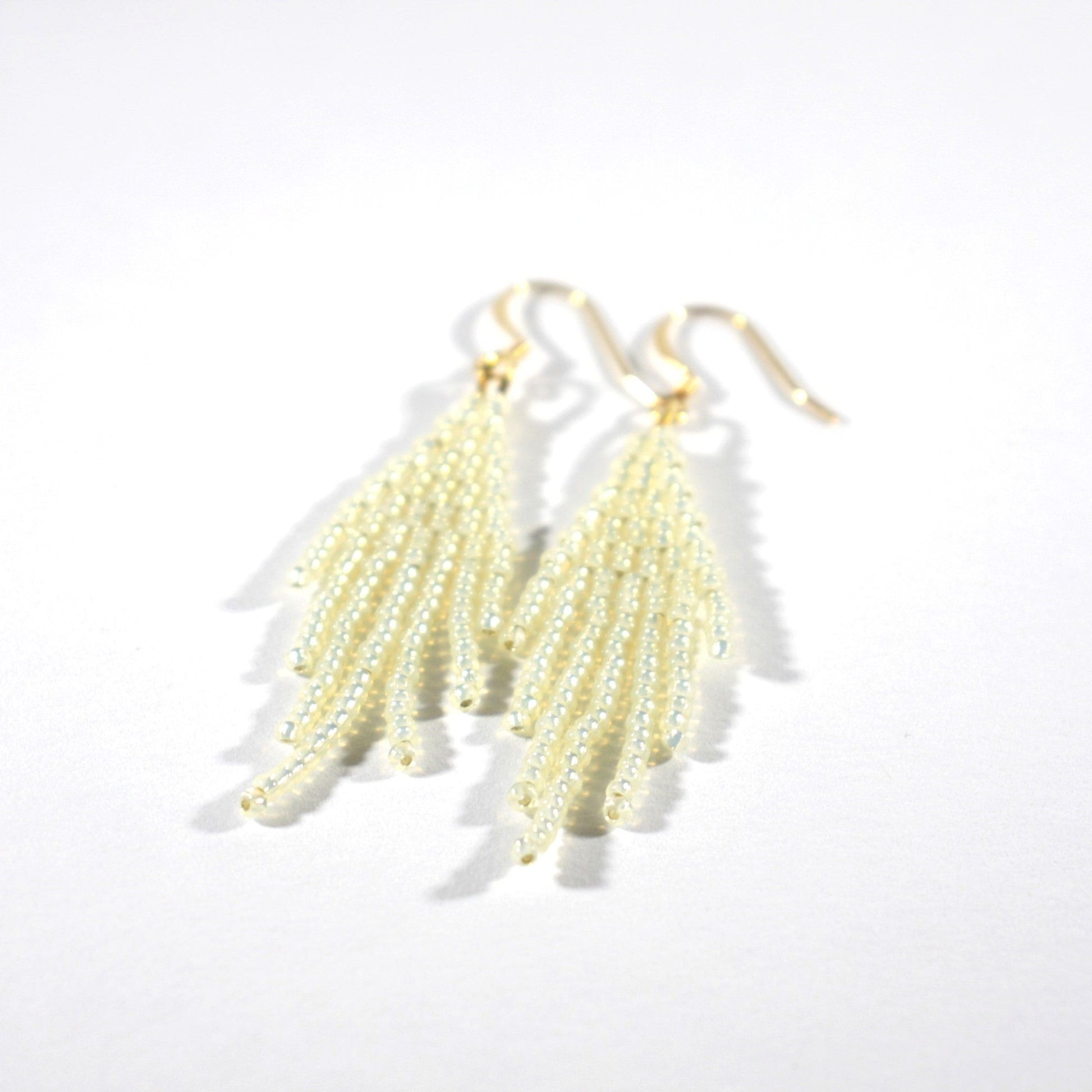 Seed bead fringe earrings sparkling cream small with gold color hooks. Lasihelmistä tehdyt pienet hapsukorvakorut väriltään kimalteleva kerma. Koulut ovat kullattua nikkelitöntä korumetallia.