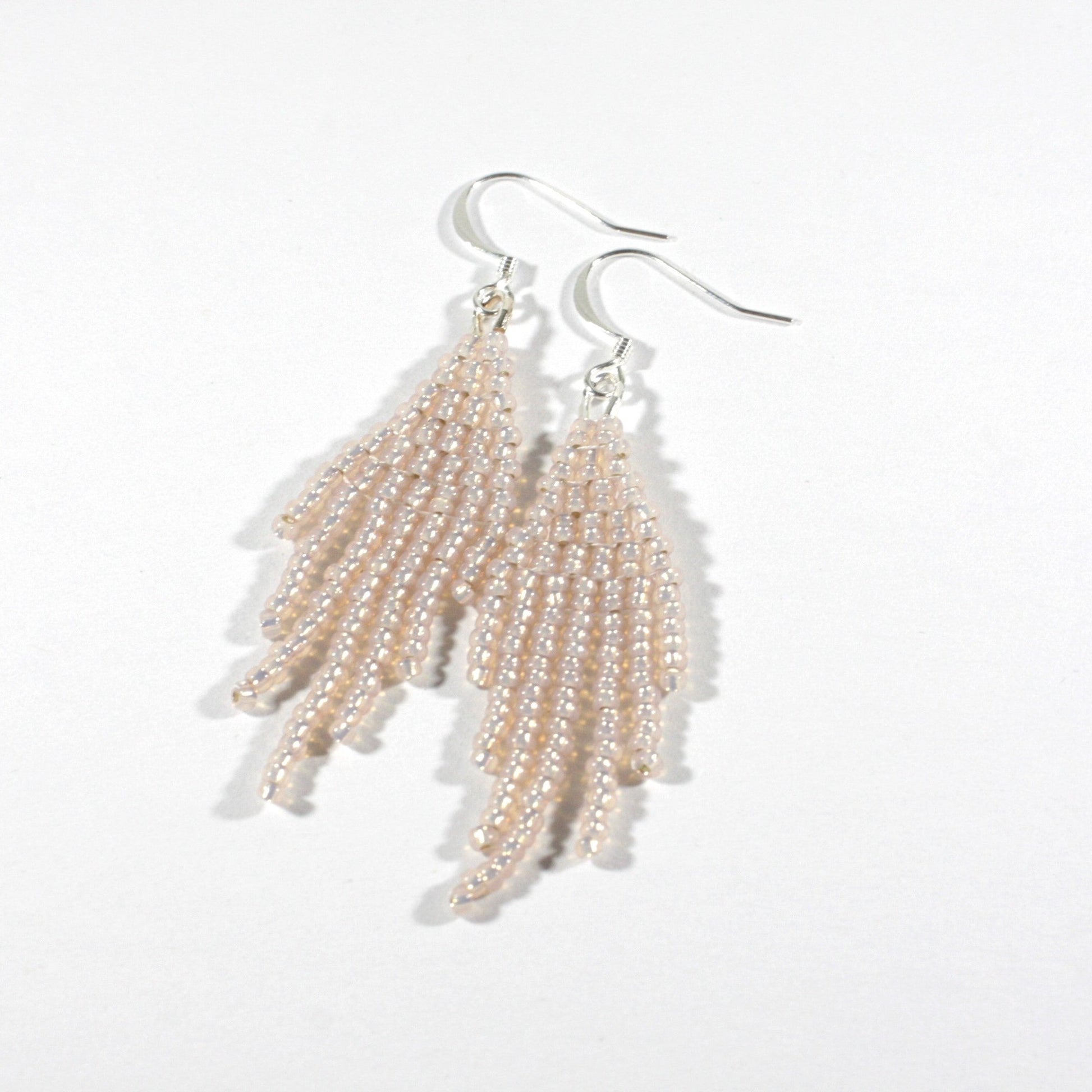 Seed bead fringe earrings small sparkling light rose with silver color hooks. Pienistä lasihelmistä kudotut roikkuvat hapsulliset korvakorut väriltään kimalteleva vaalea ruusu. Korvakoruissa on hopeanväriset koukut.