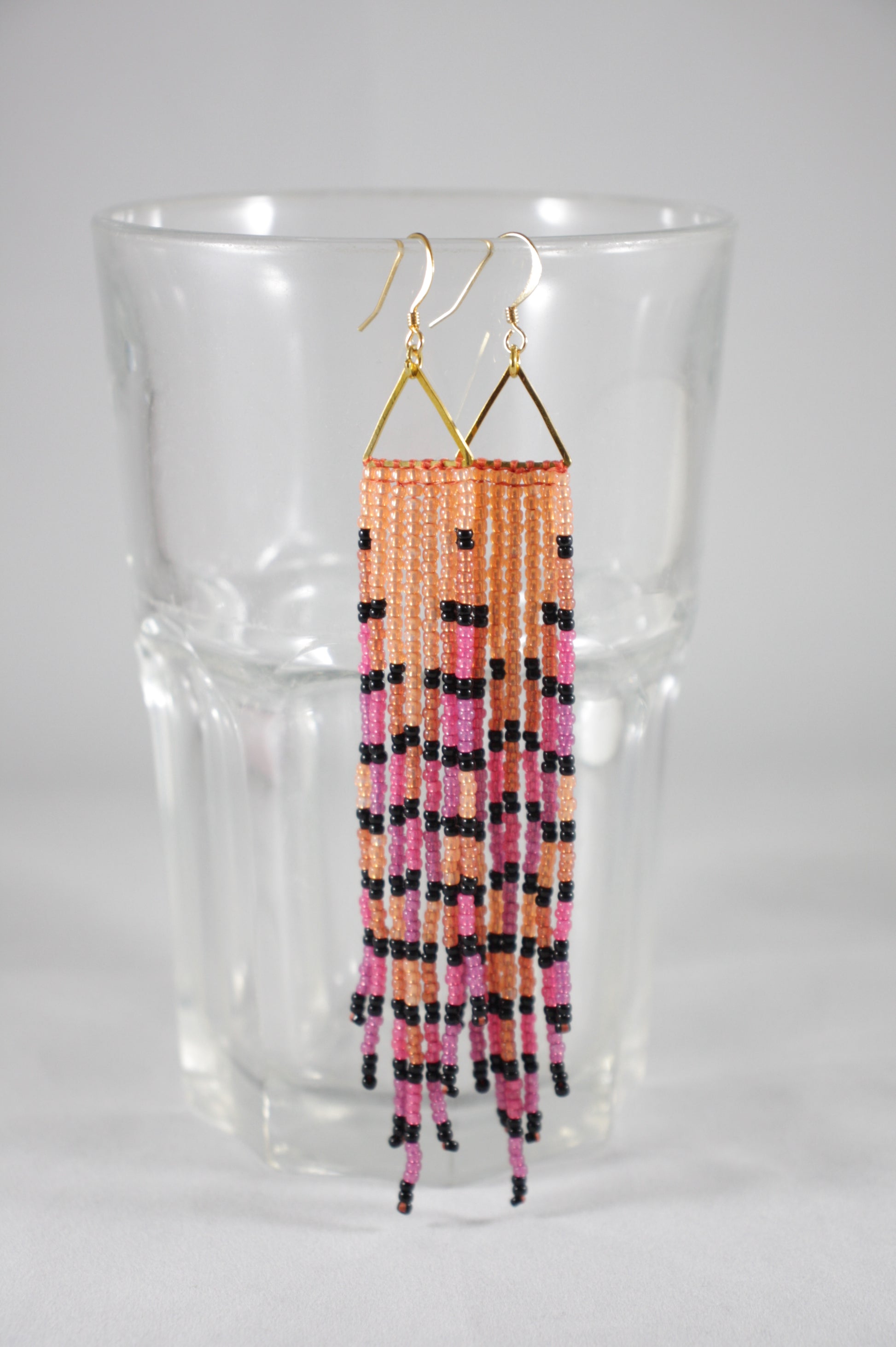 Long seed bead fringe earrings with gold plated triangle links and earrings hooks. Multicolor, orange, rasperry violet and black stripes.