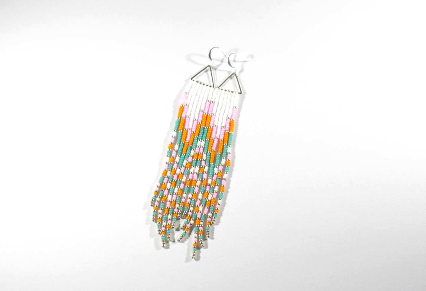 Long fringe seed bead earrings with silver color triangle links and hooks. Fringe color are white, pink, orange and turquoise with silver color beads in between.