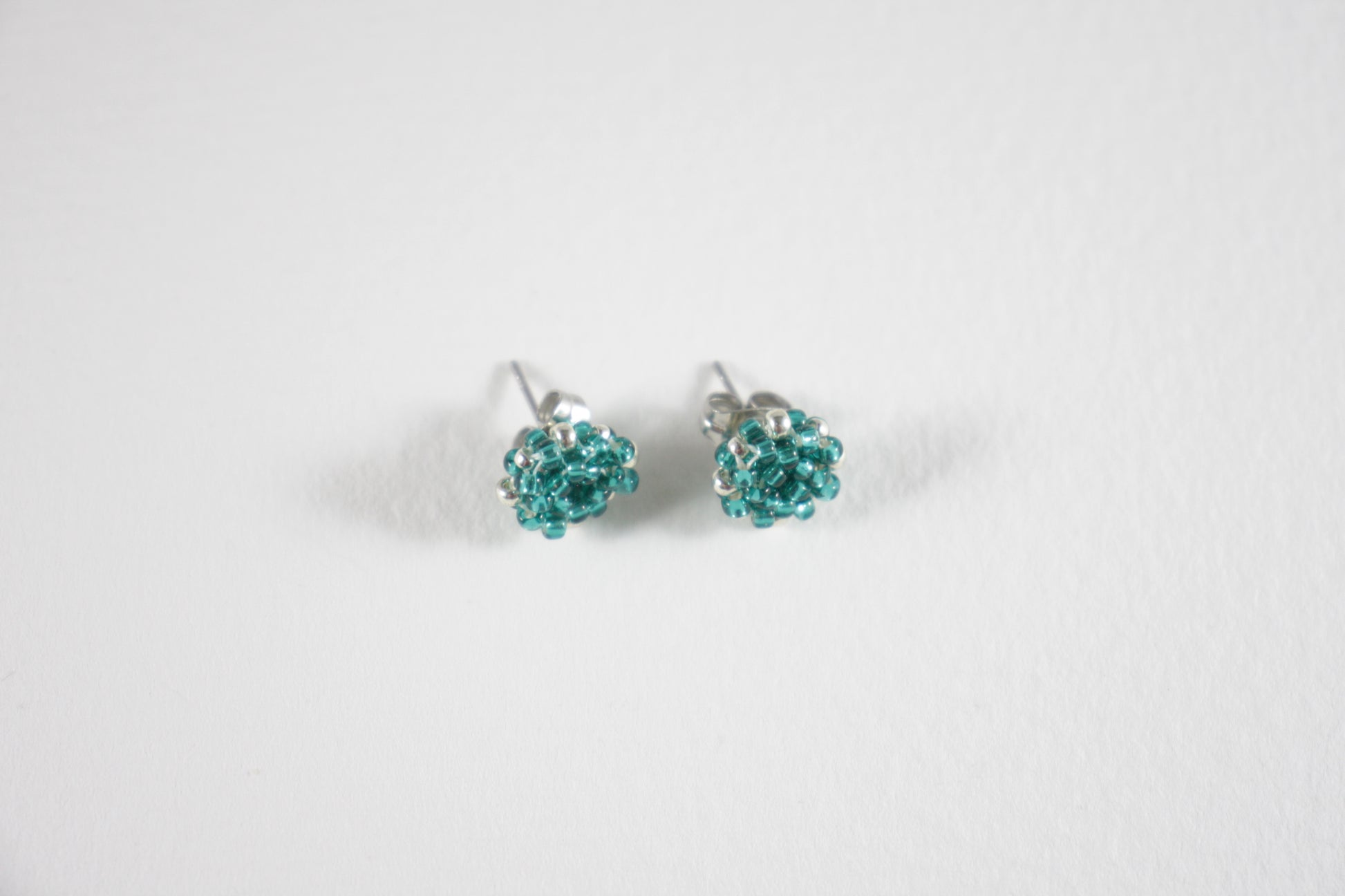 Seed bead stud earrings teal green turquoise and silver color with stainless steel stud.