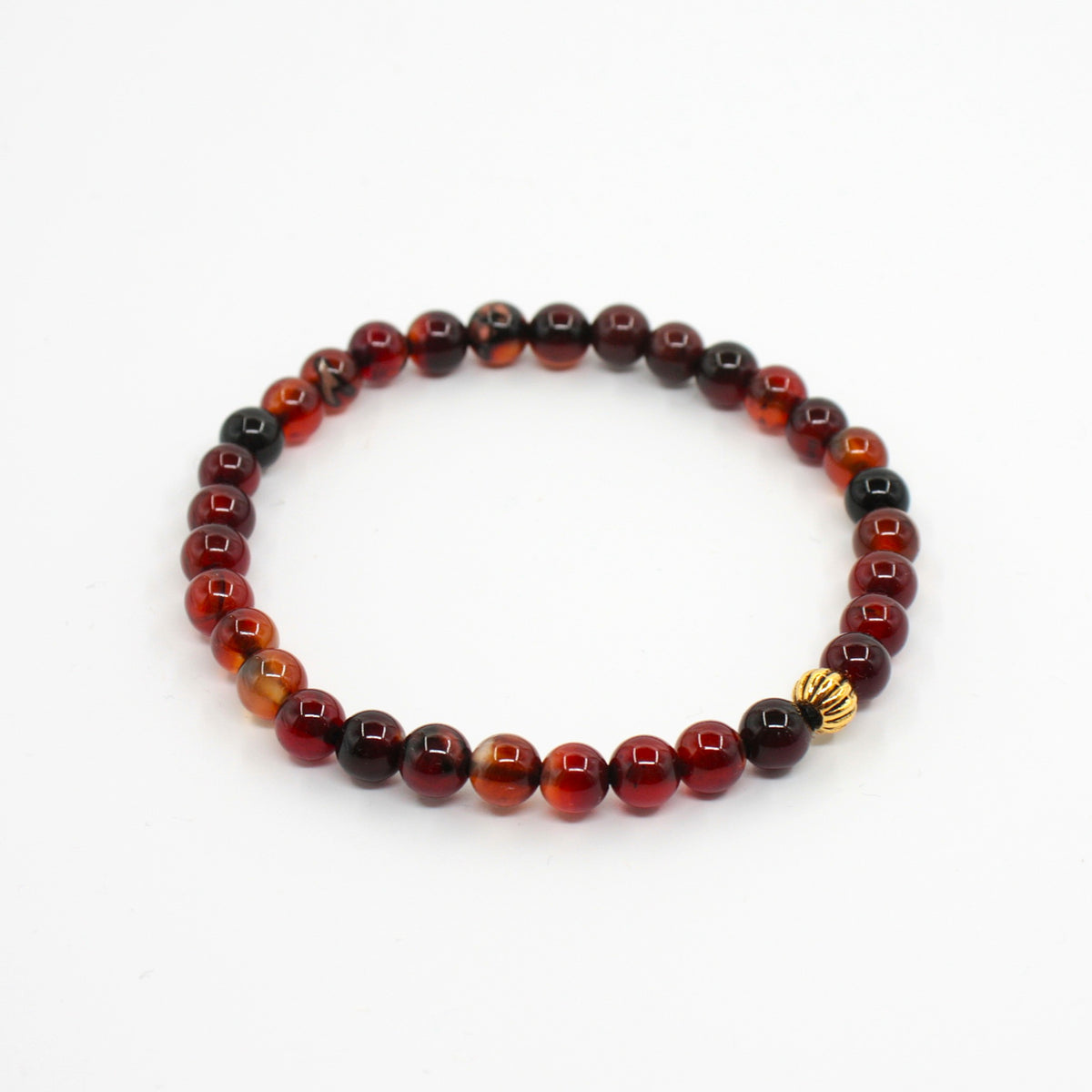 Ruskean sävyinen unelma-akaatti rannekoru valkoisella alustalla.  
A brown-toned Dream Agate bracelet on a white surface.