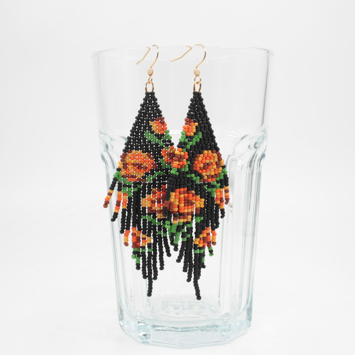 Seed bead fringe earrings matte black wit orange brown roses pattern. Pitkät roikkuvat hapsuhelmikorvakorut. Pohjaväri on mattamusta, jossa oranssin ja ruskean sävyisiä ruusukuvioita.