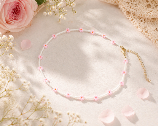 Daisy chain choker necklace white with pink and orange flowers. Päivänkakkara daisy chain choker kaulakoru valkoinen vaaleanpunaisilla kukilla. Kukkien keskusta on oranssi.