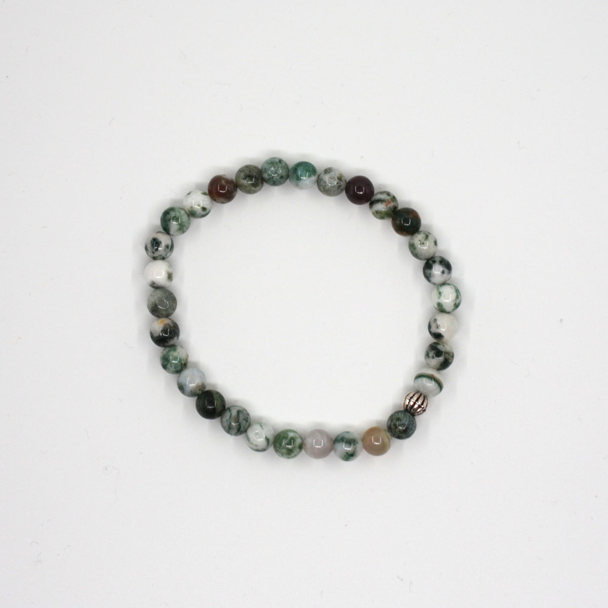 Puu-akaatti rannekoru valkoisella alustalla. Wood agate bracelet on a white surface. 